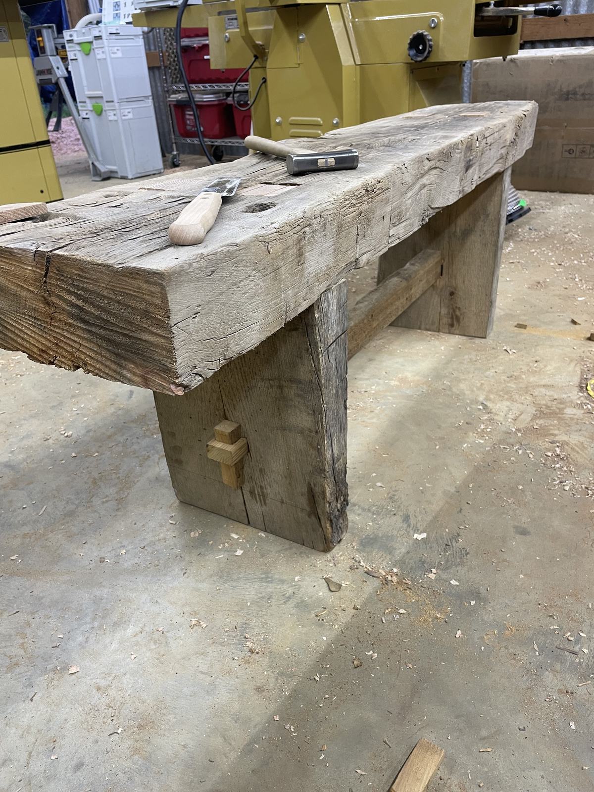 Rustic timber bench with heavy legs on the shop floor