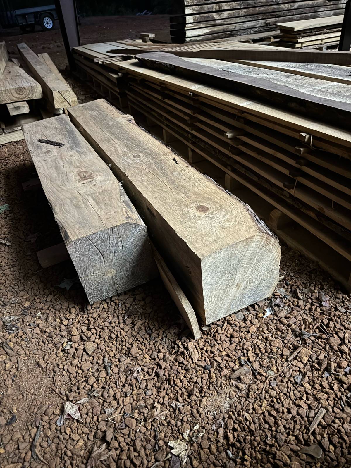 Rough-sawn timbers and stickered lumber drying at the MakerForge sawmill in East Texas