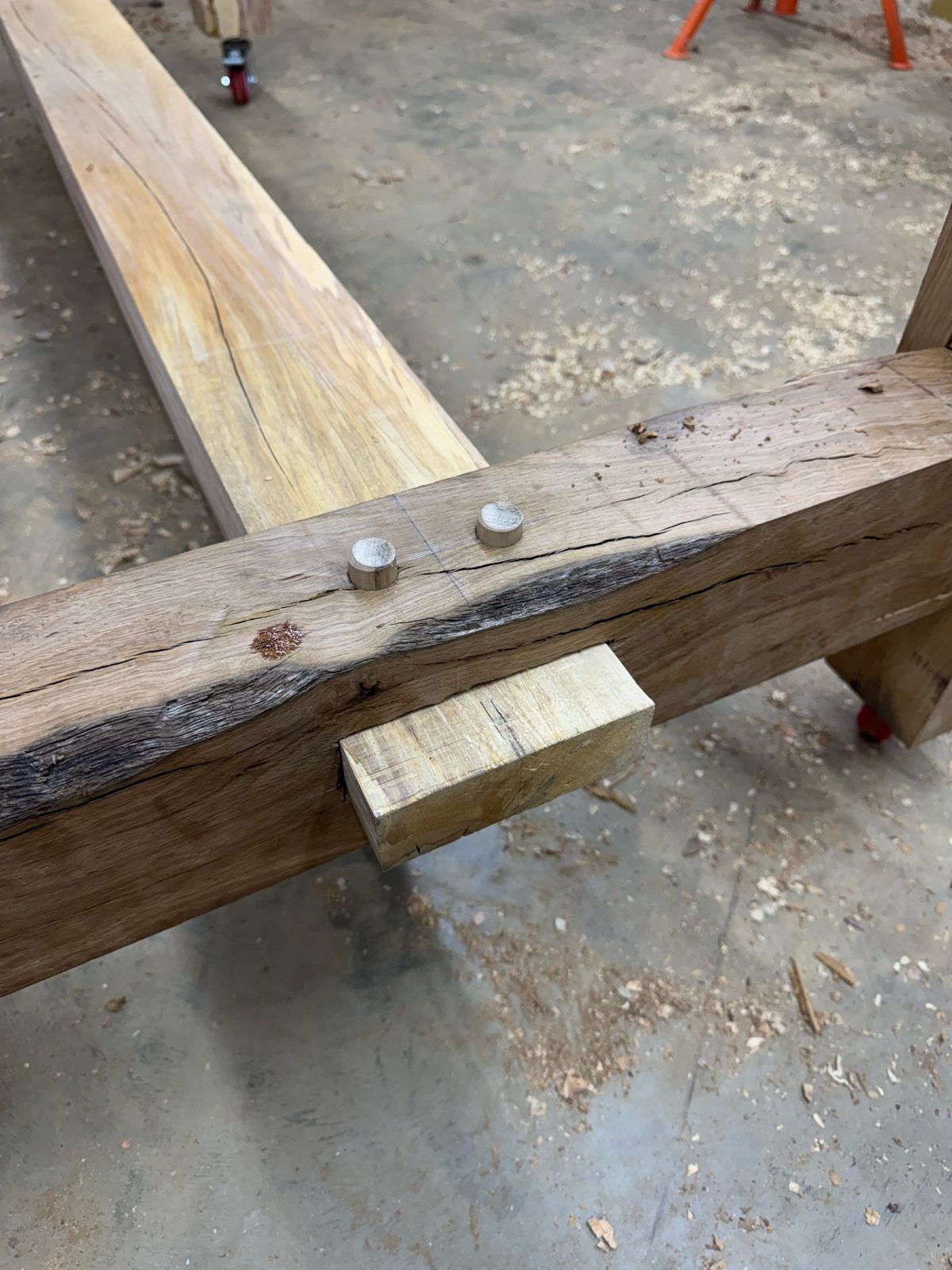 Close-up of a drawbore mortise-and-tenon joint in oak timber