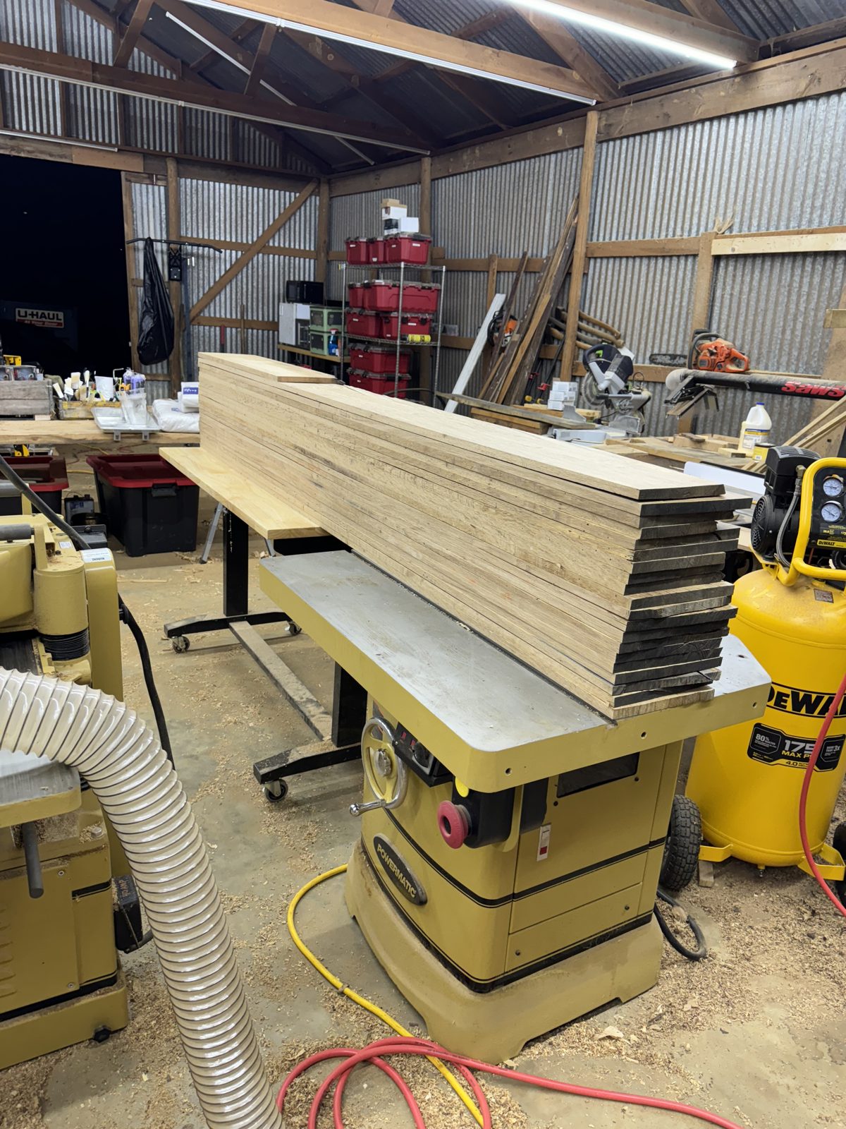 Stack of freshly ripped boards on the table saw in the woodshop