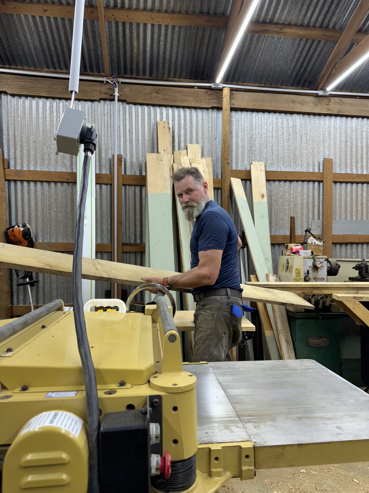 Feeding lumber through the planer in the woodshop