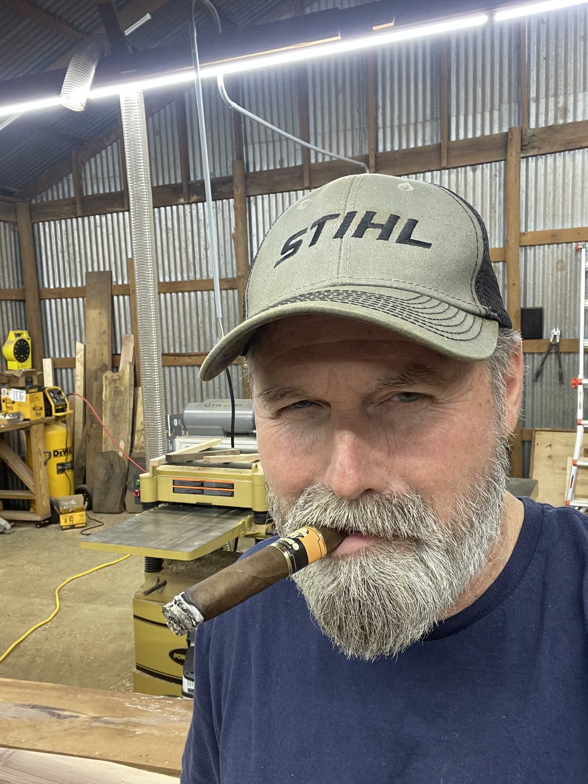 Taking a break in the woodshop, with machines and lumber behind